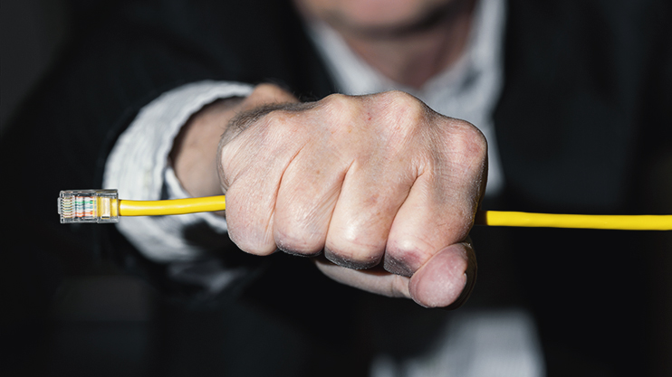 A man's outstretched fist holding an ethernet cable